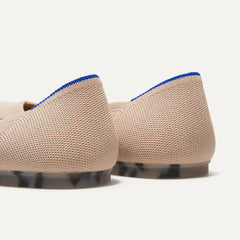 The Flat round toe shoe in Ecru shown from the back view with the heel detail.