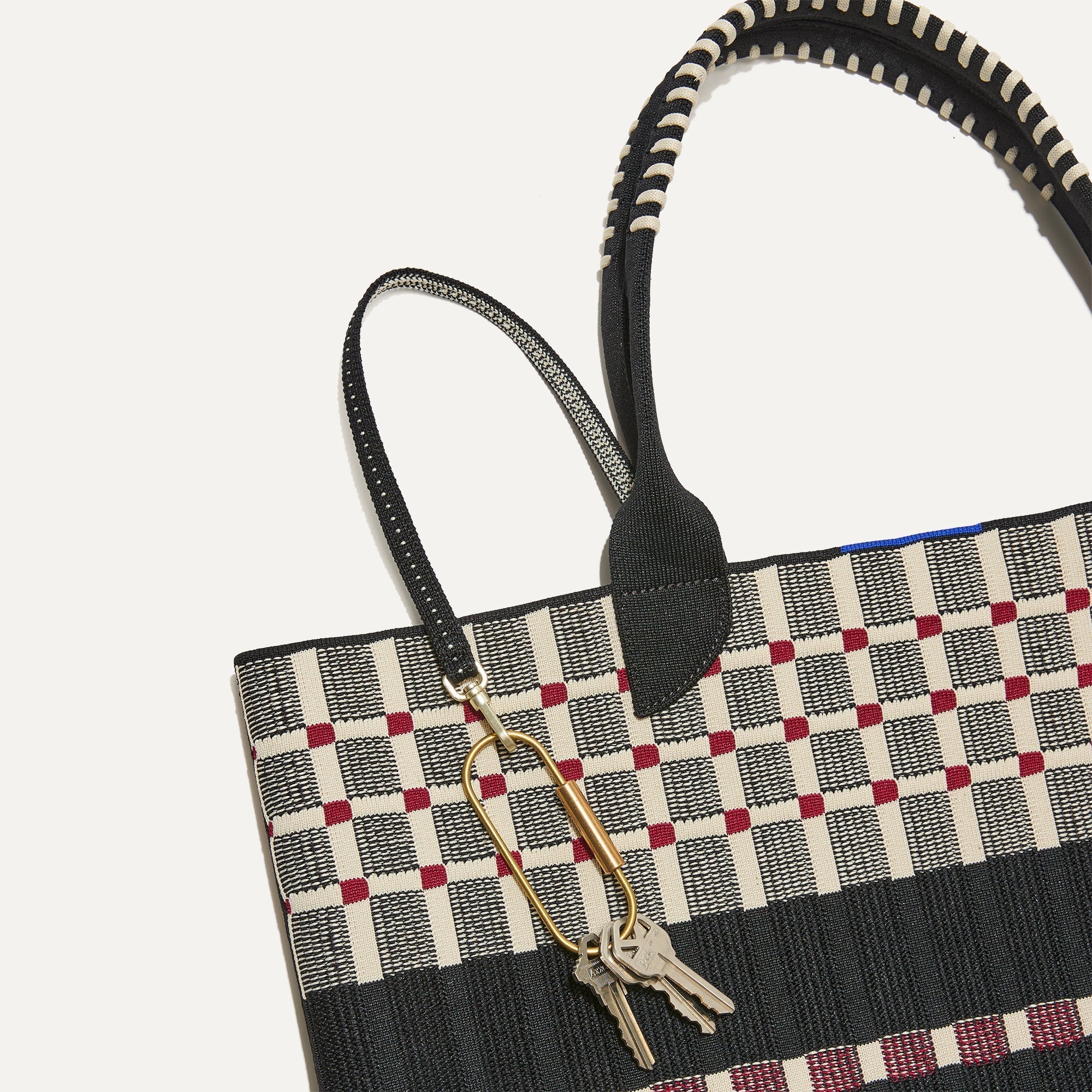 Close up of the handles and key leash detail of The Lightweight Tote in Newspaper.