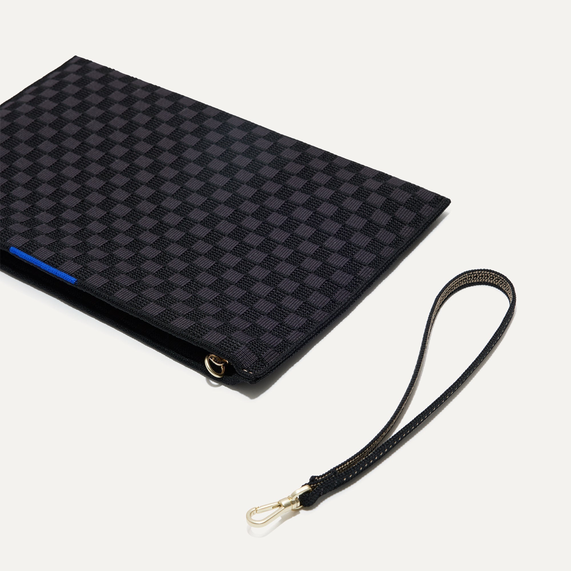 The Wristlet in Black Sand shown with the wrist strap detached.