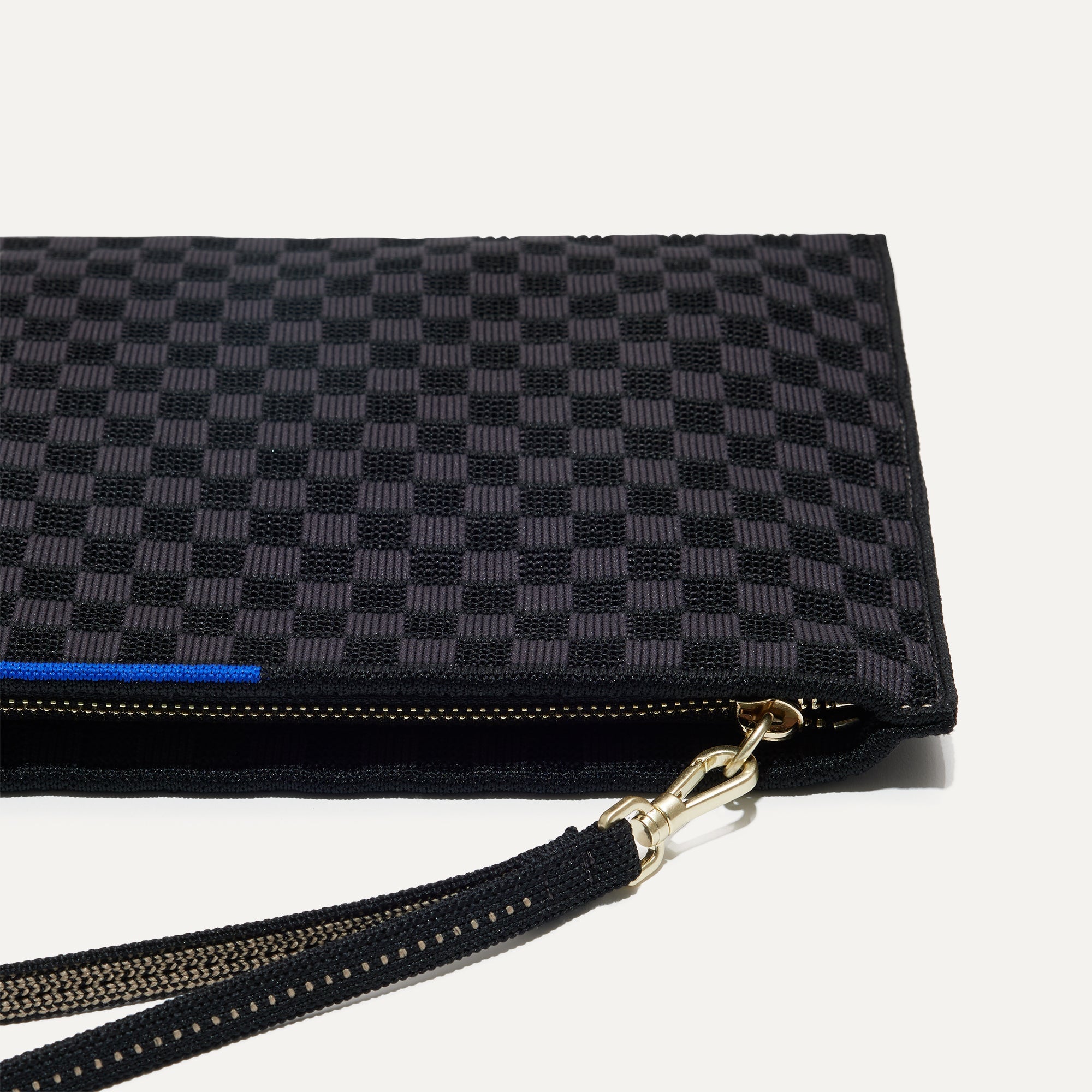 Close up of The Wristlet in Black Sand with detachable wrist strap.