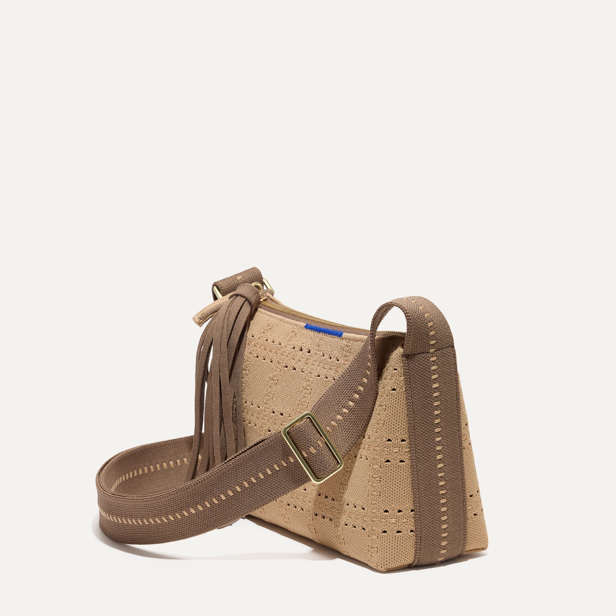 The Casual Crossbody in Brown Perf, shown from the side at an angle.